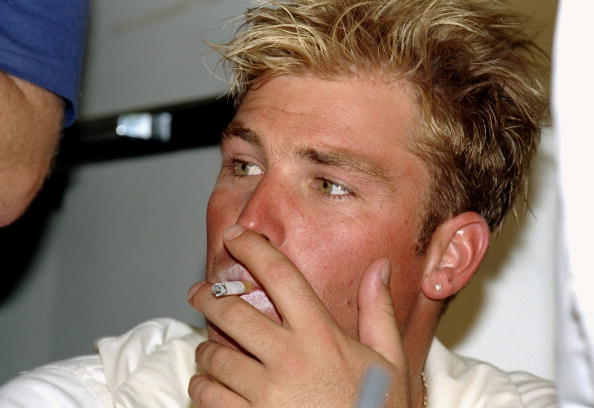 Shane Warne smokes a cigarette during his playing days | Getty