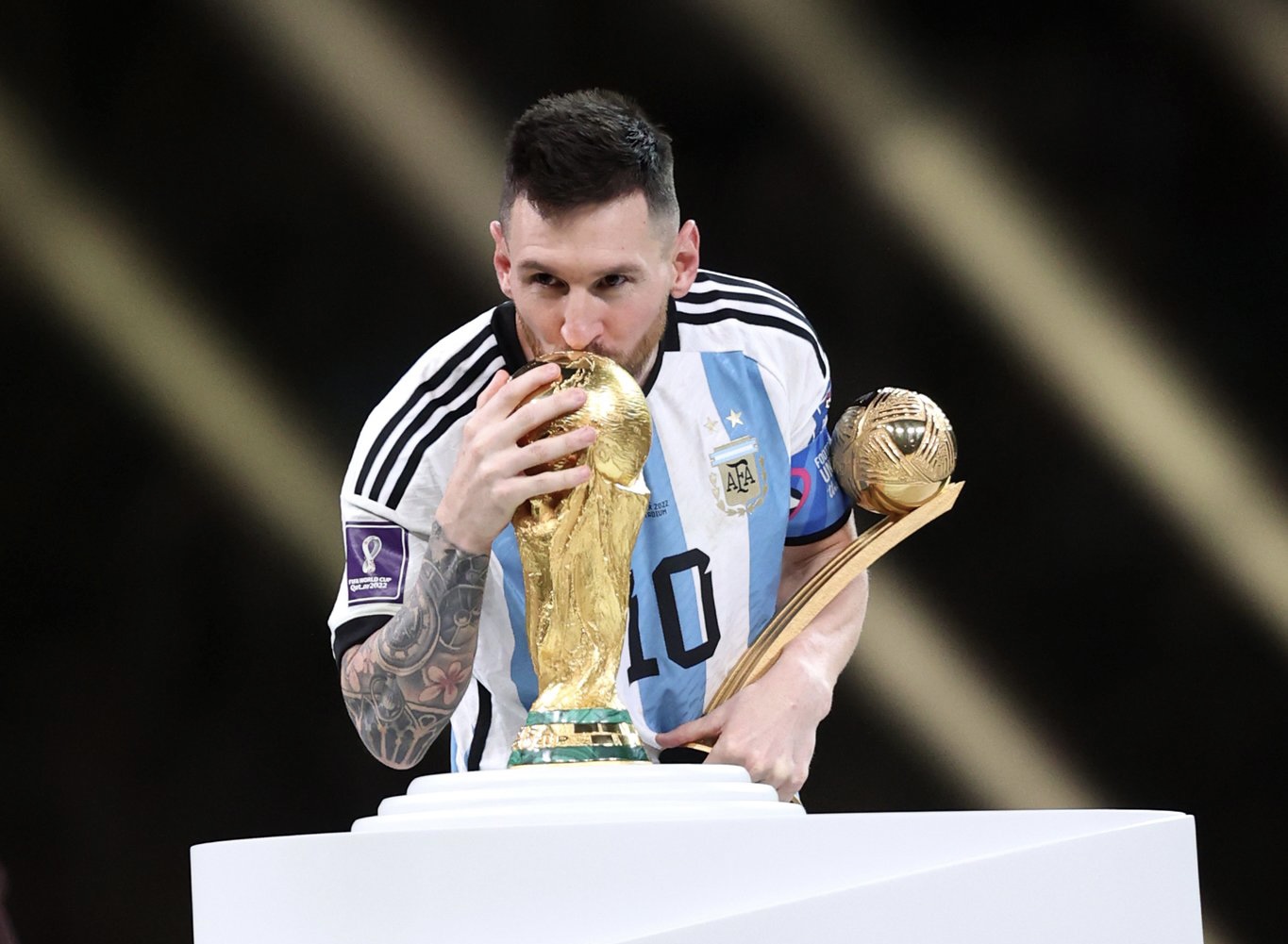 Golden Ball winner Lionel Messi kisses the FIFA World Cup trophy
