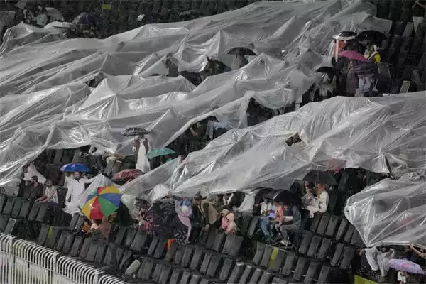 Fans used big plastic sheets to cover themselves in Pindi stadium after rain came down | X