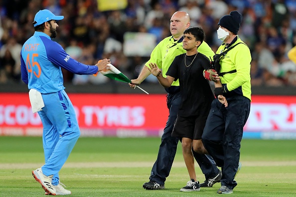 Rohit Sharma takes the Indian flag from security after the invader was captured | Getty