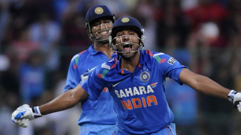 Rohit Sharma celebrates his 1st double century in ODIs as Dhoni looks on | Getty