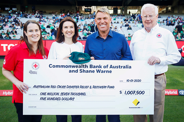 Shane Warne with the cheque for his Baggy Green | Getty