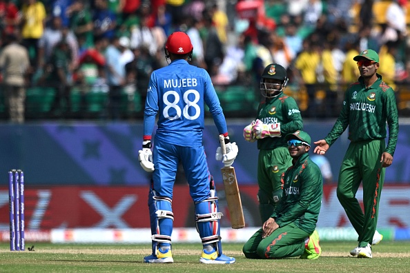 Shakib and Mushfiqur smile at Mujeeb as they wait for his box to arrive | Getty