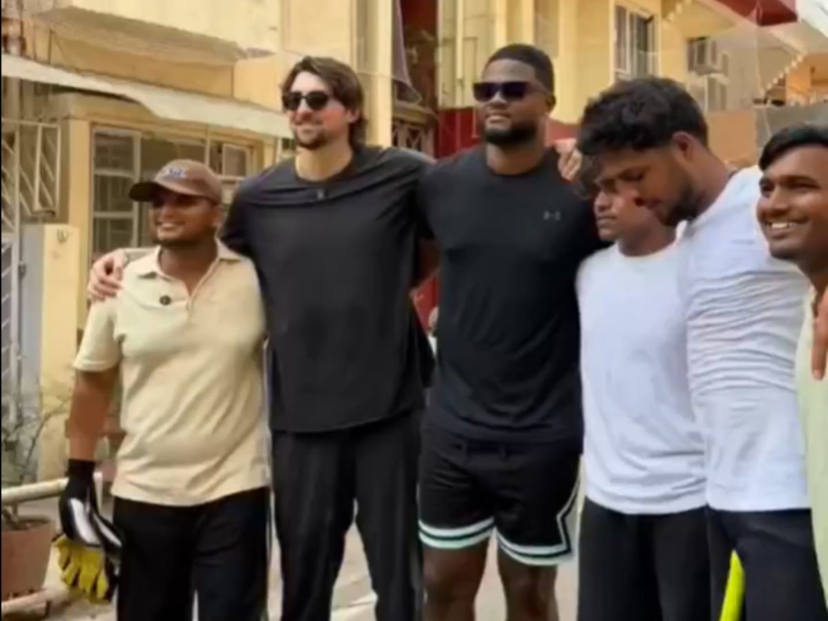 Tim David and Romario Shepherd with locals in Delhi | X